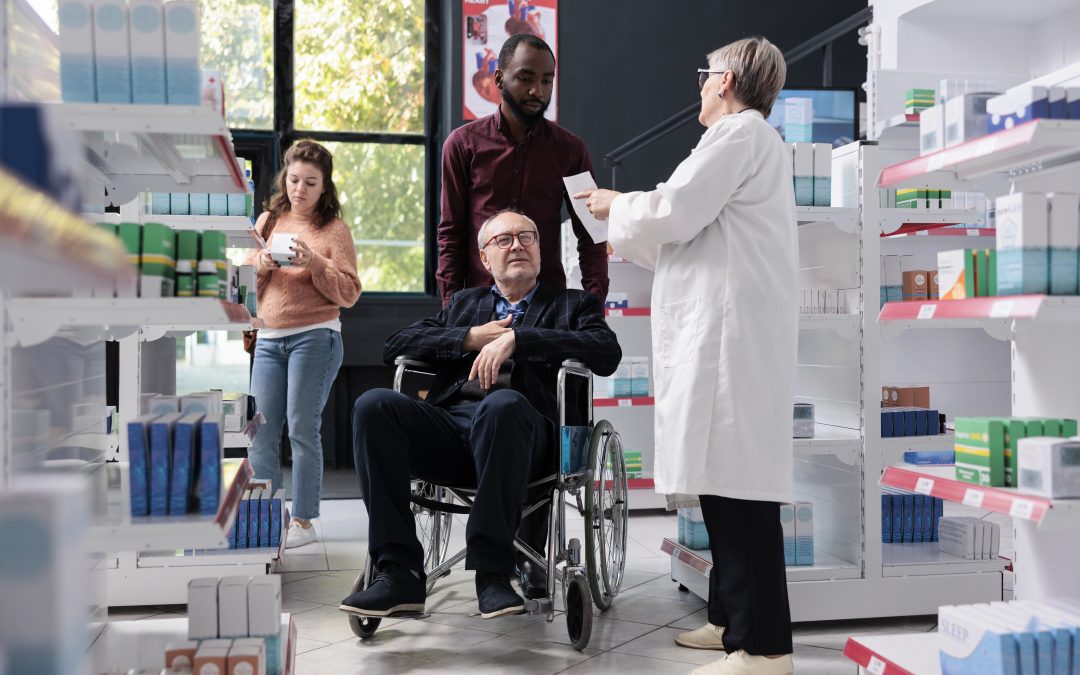 Pharmacien aidant un client en fauteuil roulant
